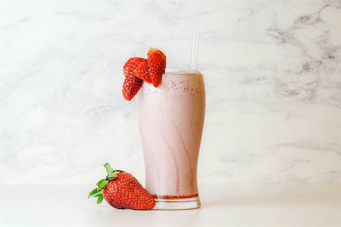 Vitamina de morango servida em copo alto
